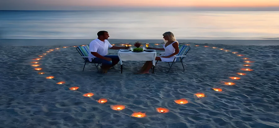 Cena en la playa dentro de un corazón de velas