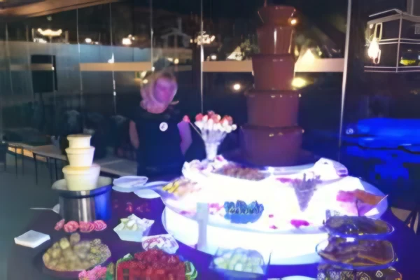 Fuente de chocolate con fruta en una fiesta nocturna