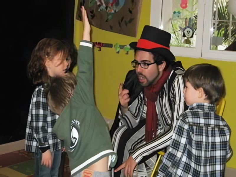 Animador con chistera y poncho jugando con niños