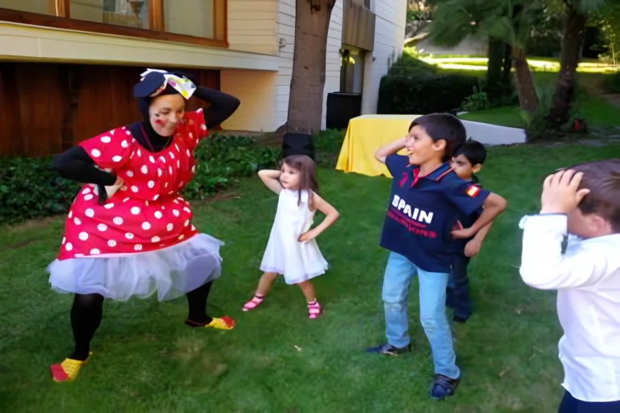 Animadora de Minnie bailando con niños en un jardín