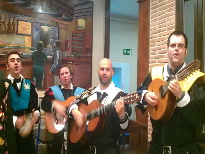 Tunos con capa cantando y tocando en un restaurante