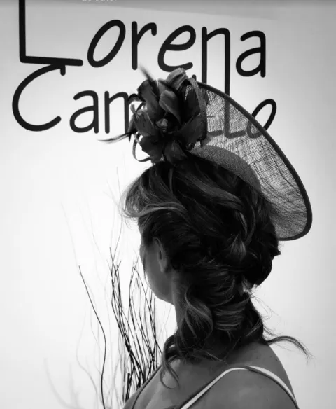 Recogido con ondas y tocado, frente a la pared del salón con el logotipo de Lorena Campillo
