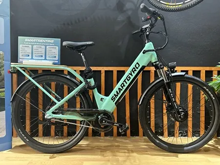 Bicicleta eléctrica Smartgyro de alquiler aparcada frente a la pared de listones de la tienda