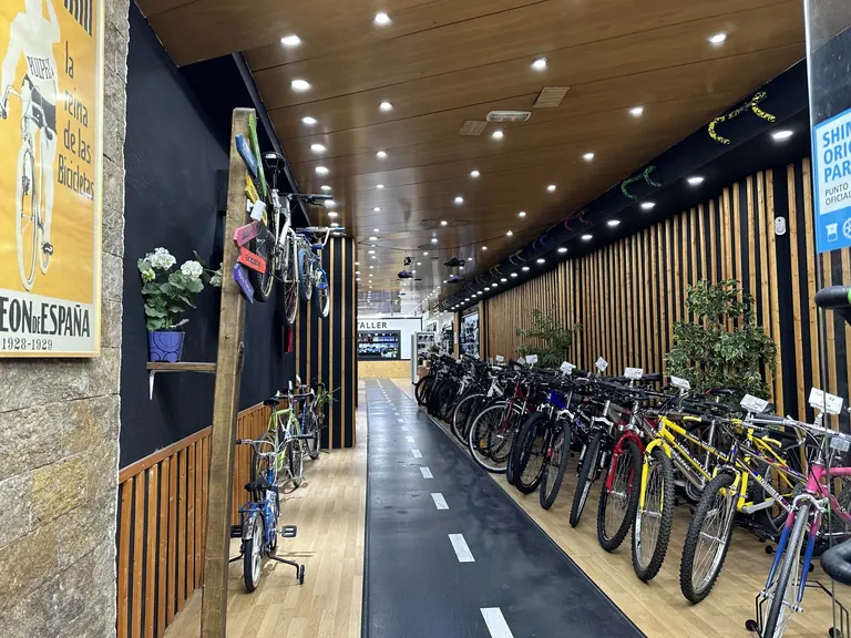 El carril bici pintado que recorre la tienda de Secondbike, con bicicletas de segunda mano aparcadas a un lado